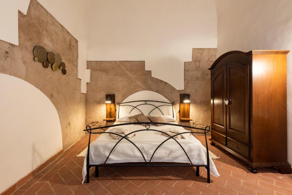 Schlafzimmer mit einem Bett und einem Holzschrank in der Unterkunft SM 32 Galilei in Pisa