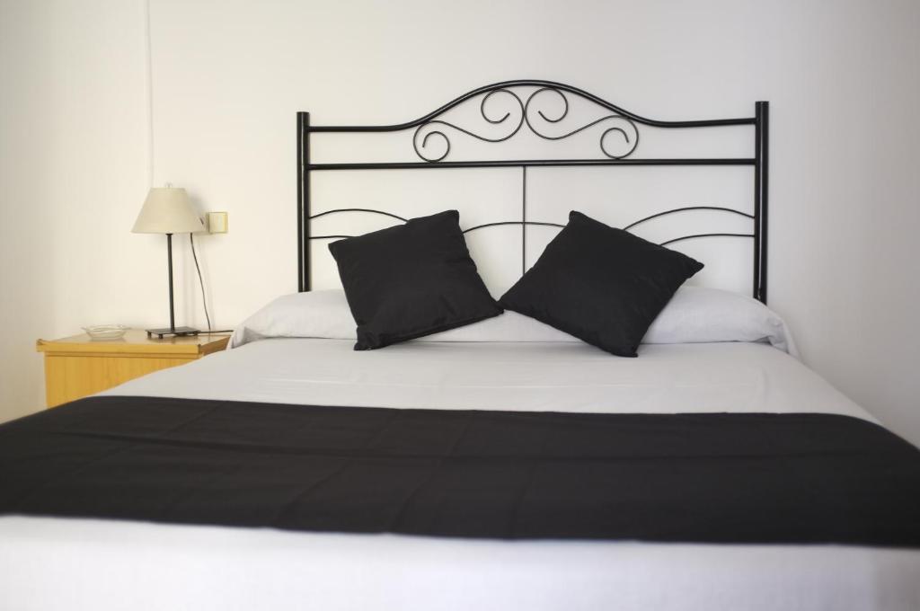 ein schwarzes und weißes Bett mit zwei schwarzen Kissen in der Unterkunft Hostal Europa in Barcelona