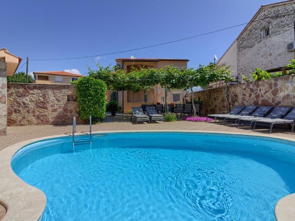 a swimming pool in a yard with a house at Spacious Holiday Home in Peroj with Private Pool in Peroj