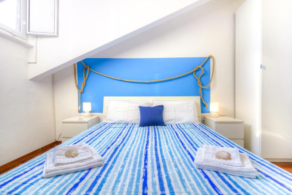 ein Schlafzimmer mit einem blauen Bett und Handtüchern darauf in der Unterkunft Il Nodo in La Spezia