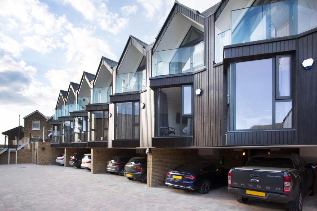 a row of houses with cars parked in a parking lot at Warehouse Holiday Lets in Whitstable
