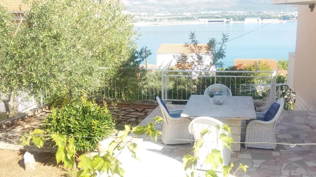 um pátio com uma mesa e cadeiras numa varanda em Apartments The View - close to the beach & parking em Trogir