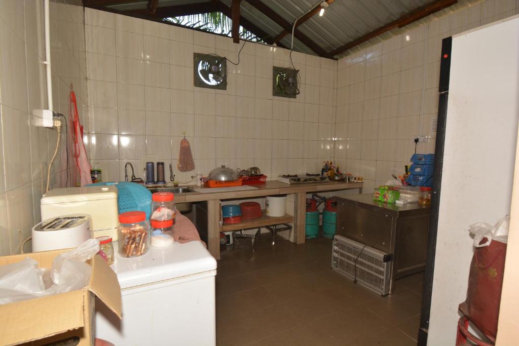a kitchen with a table and a counter top at Hemingway Cottage 海明威度假屋 in Semporna