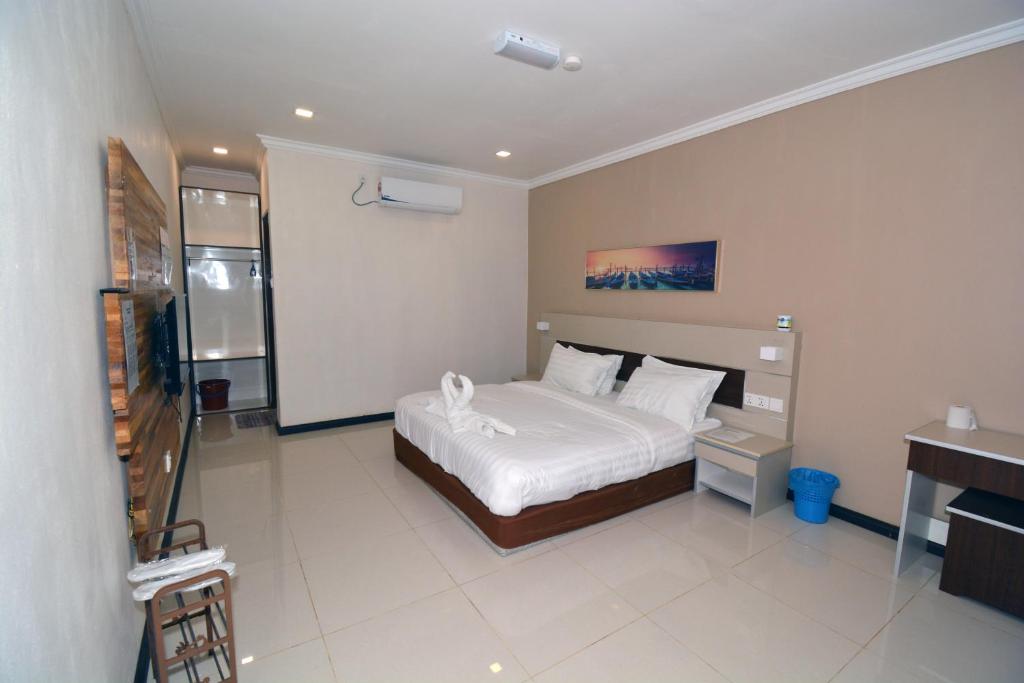 a bedroom with a bed in a room with a piano at Hemingway Cottage 海明威度假屋 in Semporna
