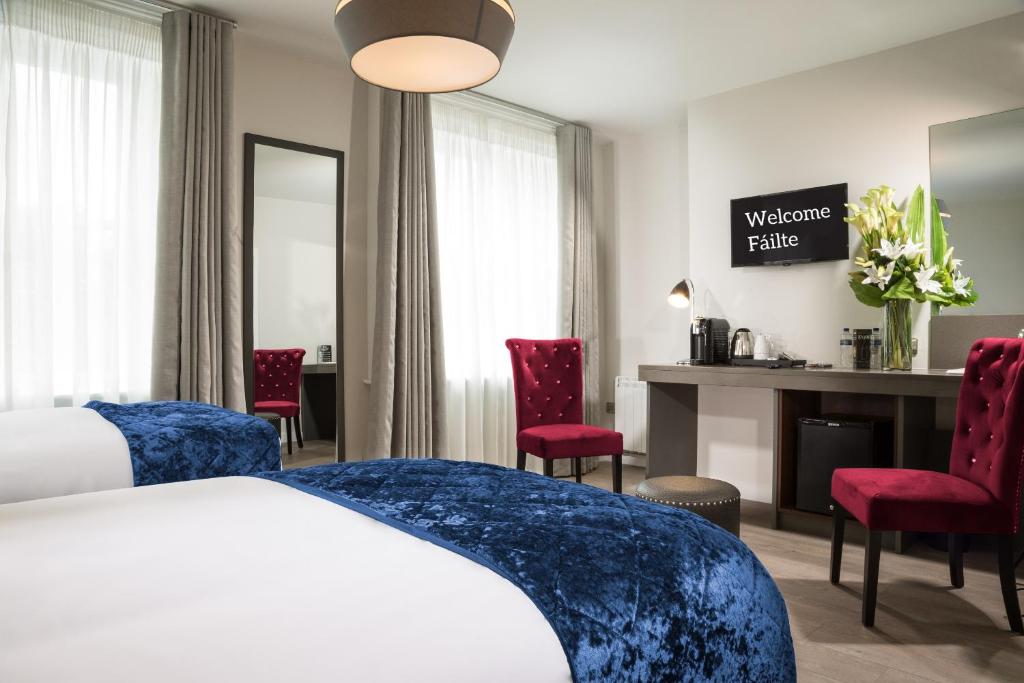 a hotel room with a bed and red chairs at No 9 Rathgar in Rathgar