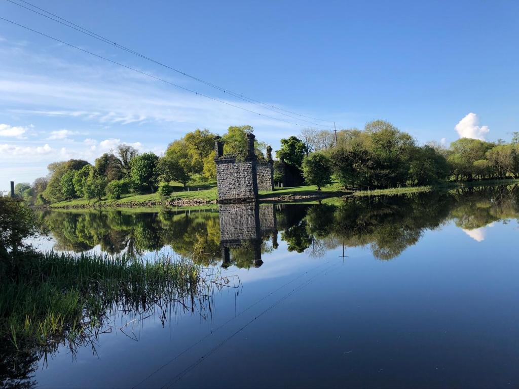 a suspension bridge over a river with its reflection in the water at Ardhowen Bay lakefront holiday accommodation in Enniskillen