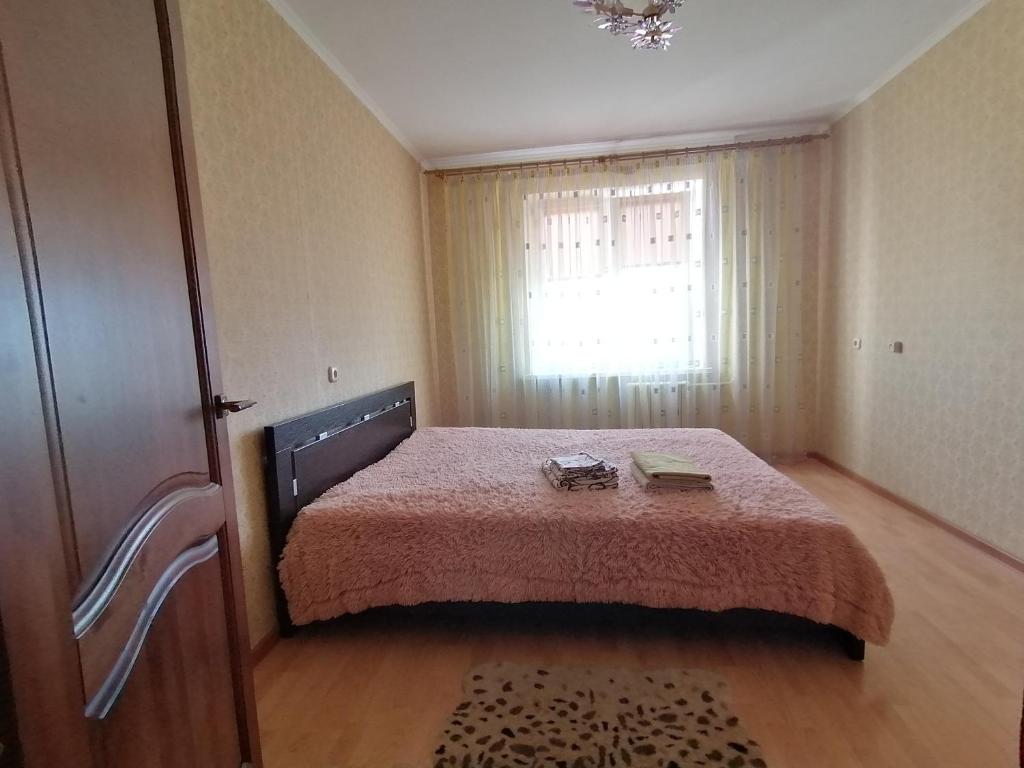a small bedroom with a bed and a window at Apartment 18 Microrayon in Zhlobin