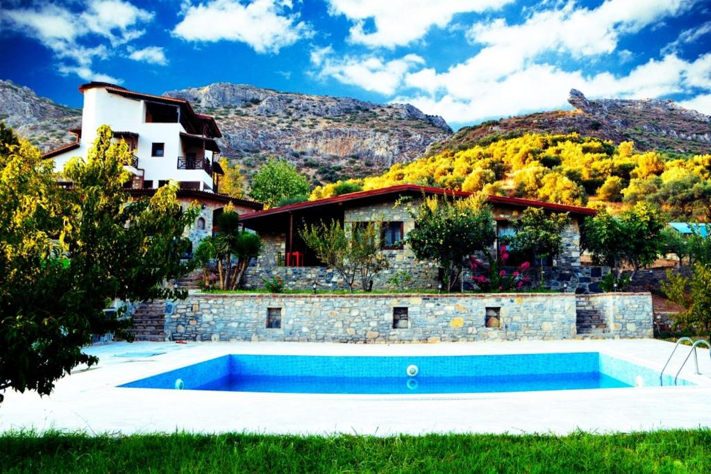 a house with a swimming pool in front of a mountain at Pir Efes Konakları in Izmir