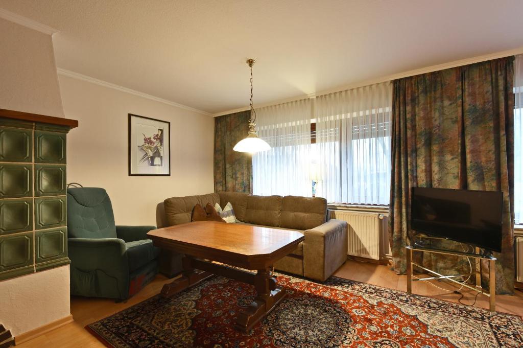salon z kanapą, stołem i telewizorem w obiekcie Monteurwohnung w mieście Emstek