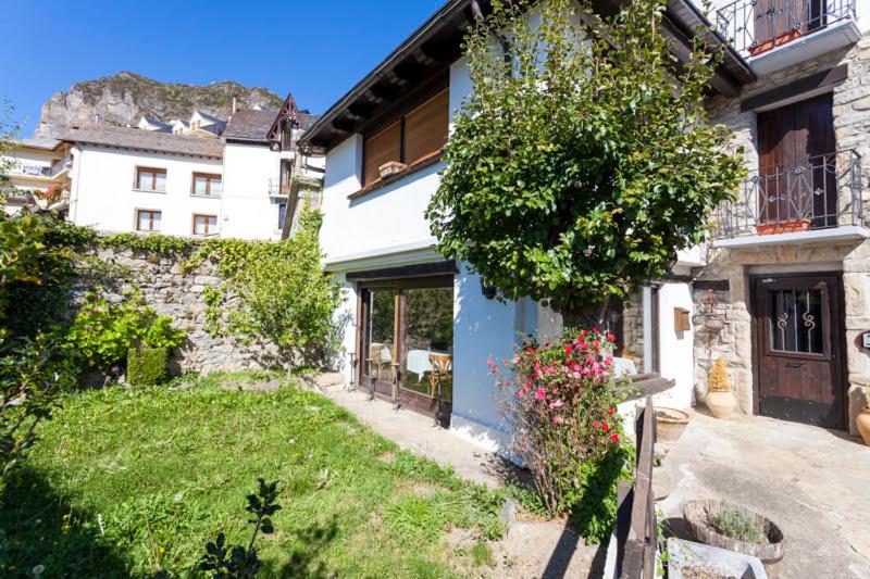 a house with a yard in front of a building at Casa Marieta Escarrilla in Escarrilla