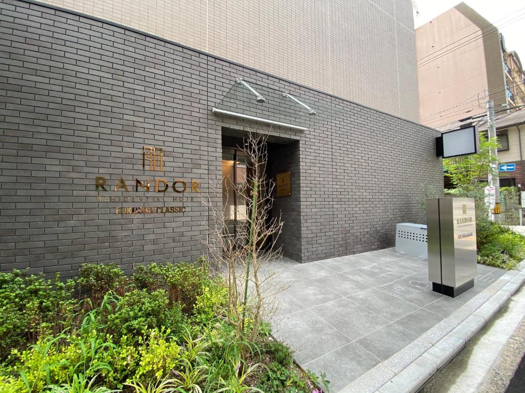 福岡的住宿－Randor Residential Hotel Fukuoka Classic，建筑的侧面有标志