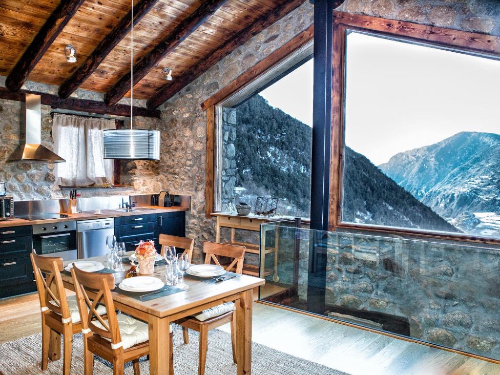 eine Küche mit einem Tisch und einem großen Fenster in der Unterkunft R de rural - Borda del Mollà in Encamp