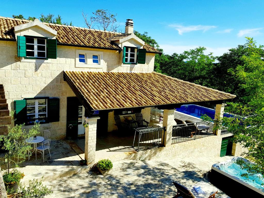 een groot stenen huis met een roestig dak bij Villa Dvori Dida Mile in Sveti Petar