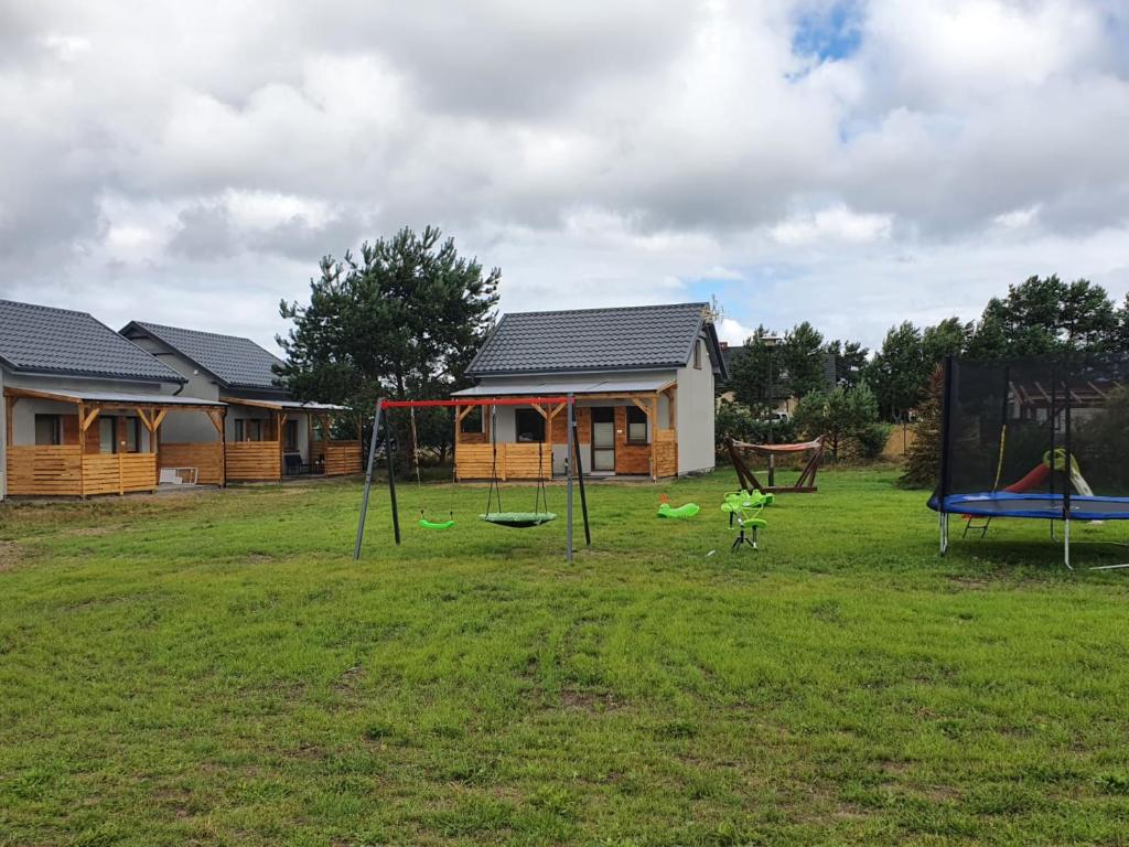 a yard with a playground with a house at Zakątek w Zaciszu in Ustka