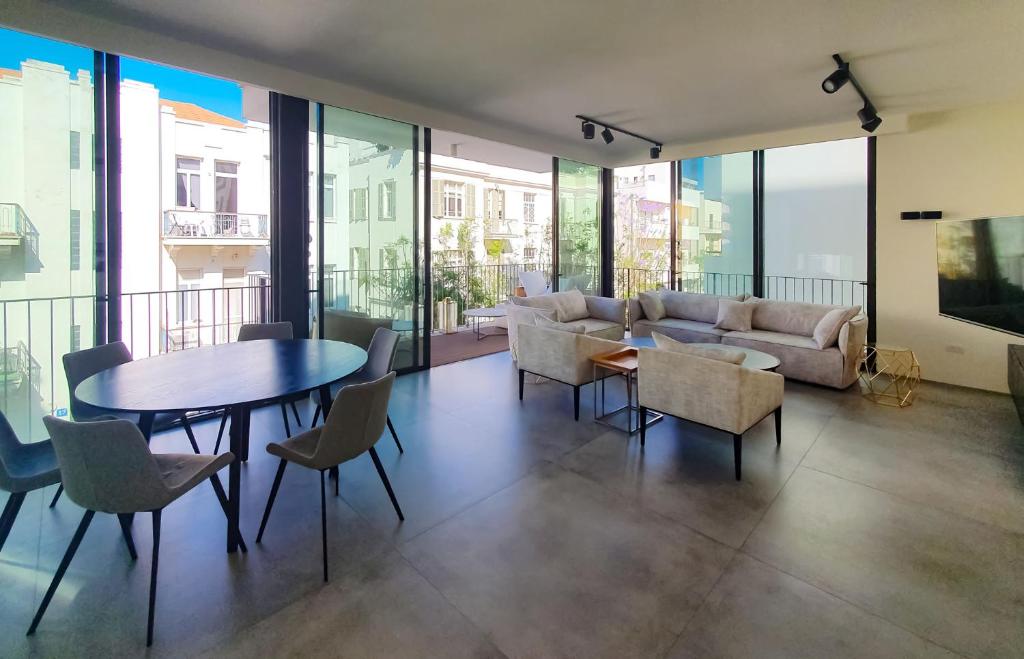 sala de estar con mesa, sillas y sofá en BnBIsrael apartments - Yavne Brillant en Tel Aviv