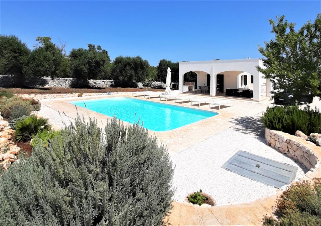 a swimming pool in the middle of a yard at Trullo Tranquillo Ostuni in Ostuni