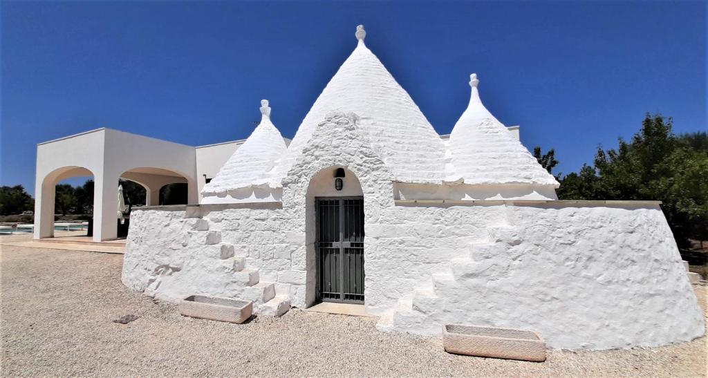 een wit gebouw met spikes aan de zijkant bij Trullo Tranquillo Ostuni in Ostuni