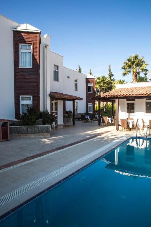 a villa with a swimming pool next to a house at Bodrum Marma Otel in Bodrum City