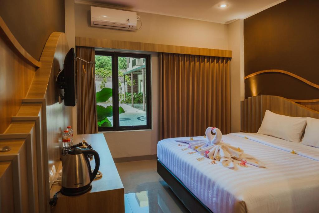 Una habitación de hotel con una cama con una toalla. en panfila hotel, en Kuta Lombok
