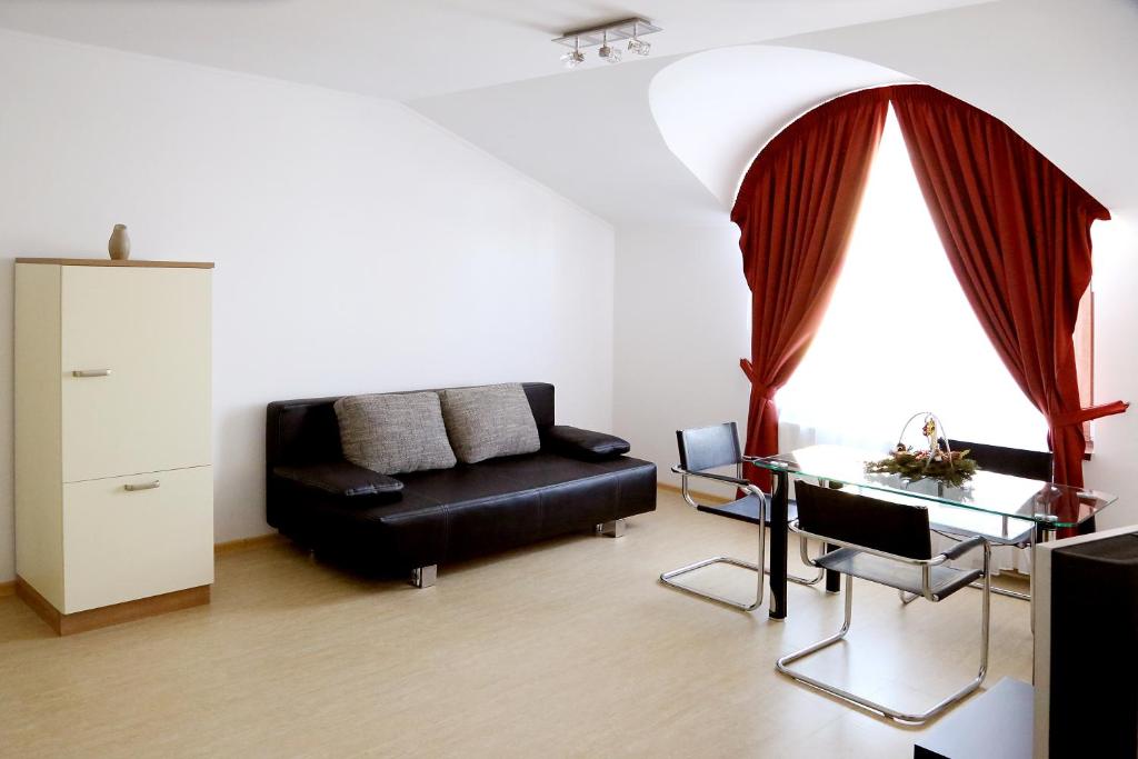 sala de estar con sofá negro y mesa de cristal en Vila Nona Apartment en Sibiu