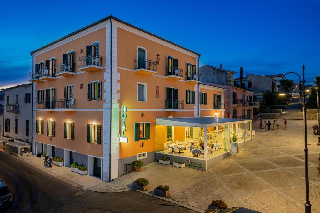 un immeuble d'appartements avec un restaurant en face de celui-ci dans l'établissement Hotel Marinaro, à Santa Teresa Gallura