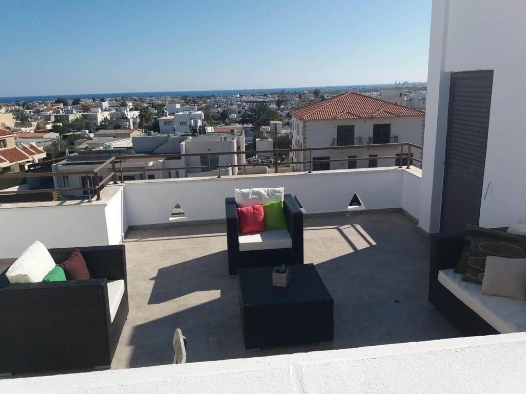 a balcony with two chairs and a view of a city at Two bedroom Duplex :Mountain and Sea view in Larnaca