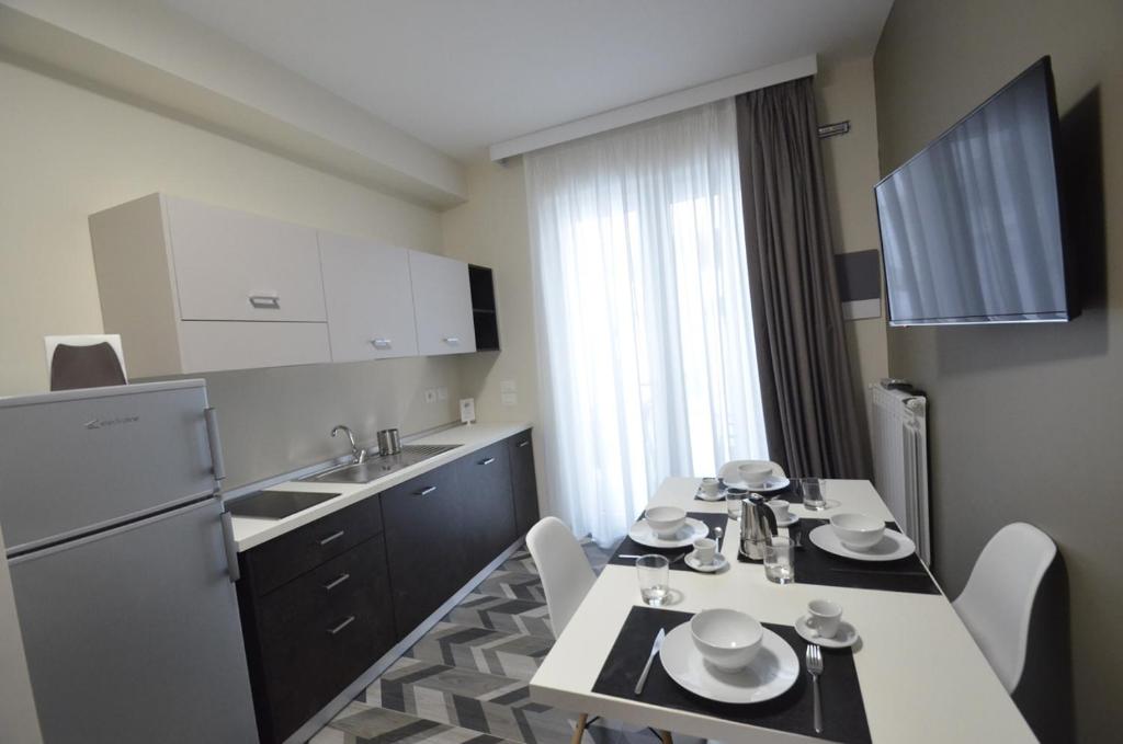 kuchnia ze stołem, krzesłami i lodówką w obiekcie Riva 33 Apartments w mieście Porto Cesareo