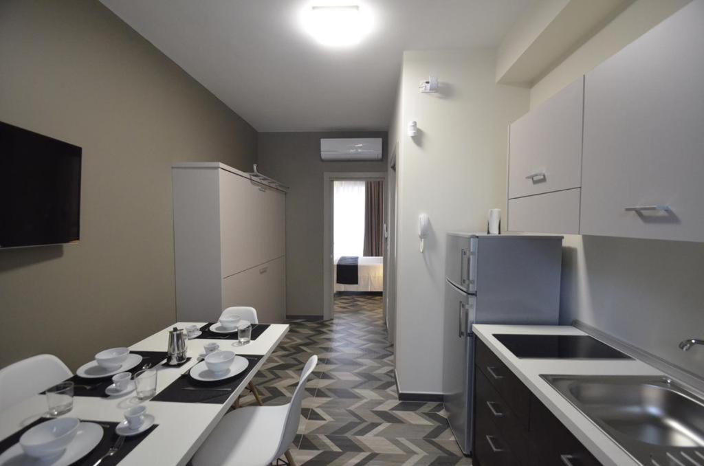 kuchnia ze stołem i lodówką w obiekcie Riva 33 Apartments w mieście Porto Cesareo
