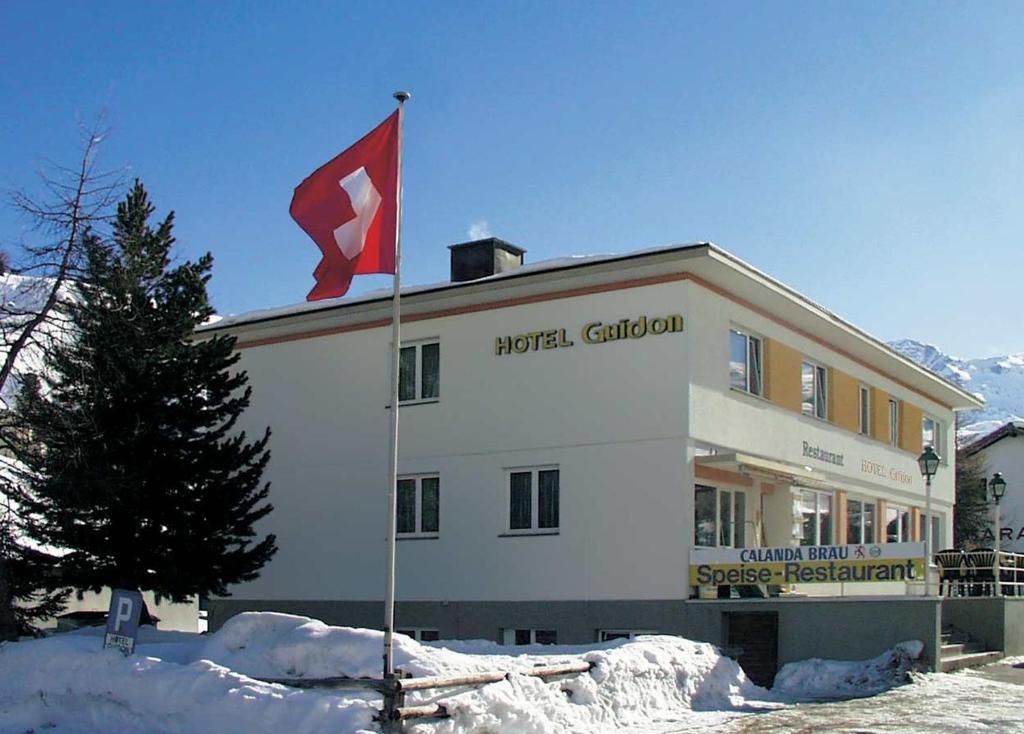 a building with a canadian flag in front of it at Hotel Guidon Zimmer in Bivio
