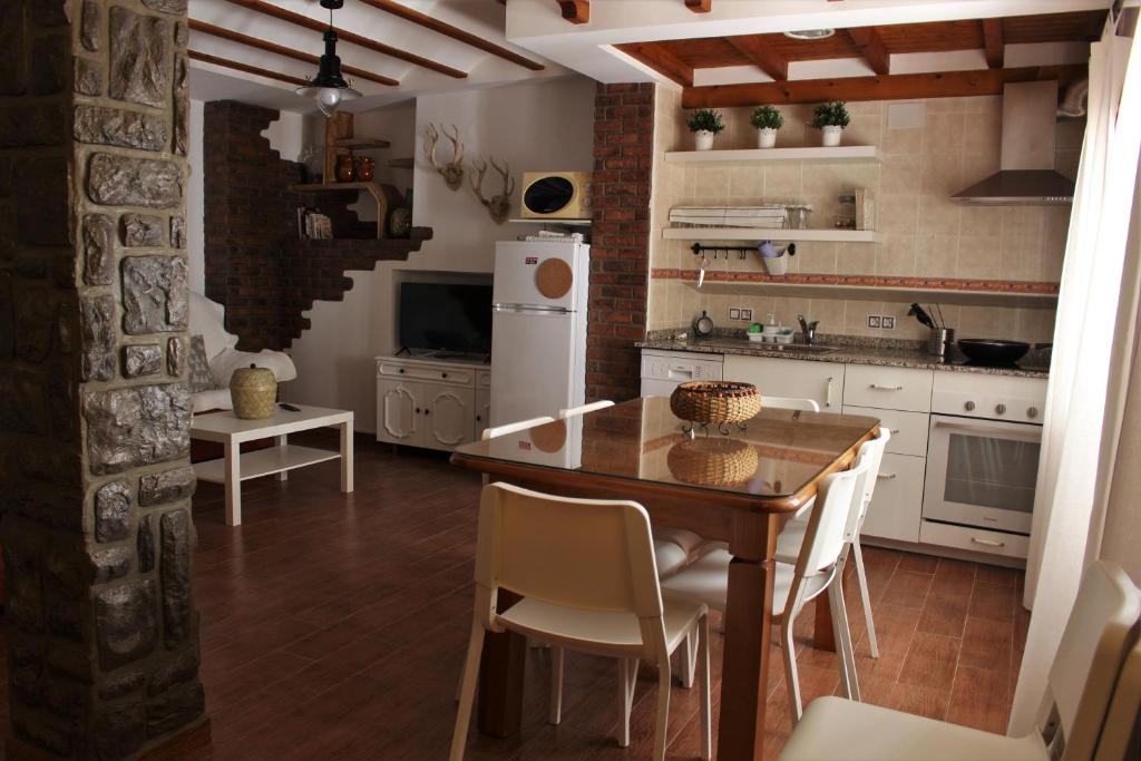 cocina con mesa de madera y electrodomésticos blancos en Alojamiento Rural La Cochera, en Castril