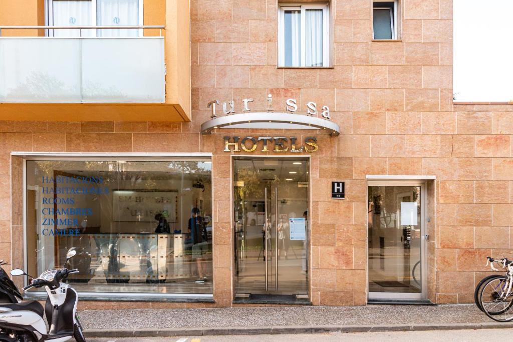 a store front of a building with a motorcycle parked outside at Hotel Turissa in Tossa de Mar