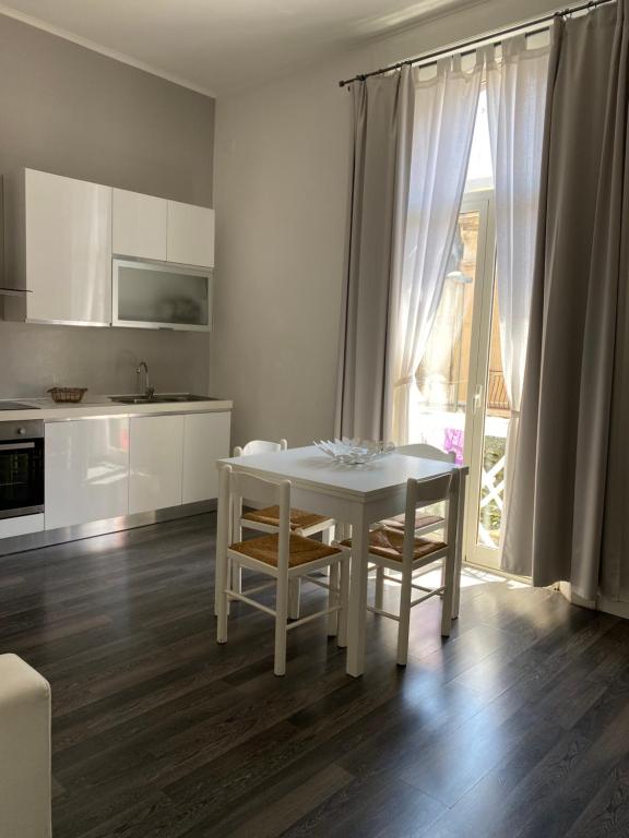 a white kitchen with a white table and chairs at Civico 14 in Reggio di Calabria
