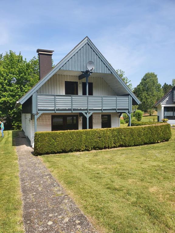 una casa con un patio de hierba delante de ella en Silbersee90, en Frielendorf