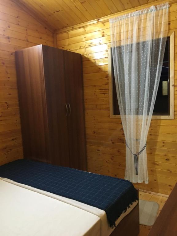 a small bedroom with a bed and a window at Violet Village in Borsh