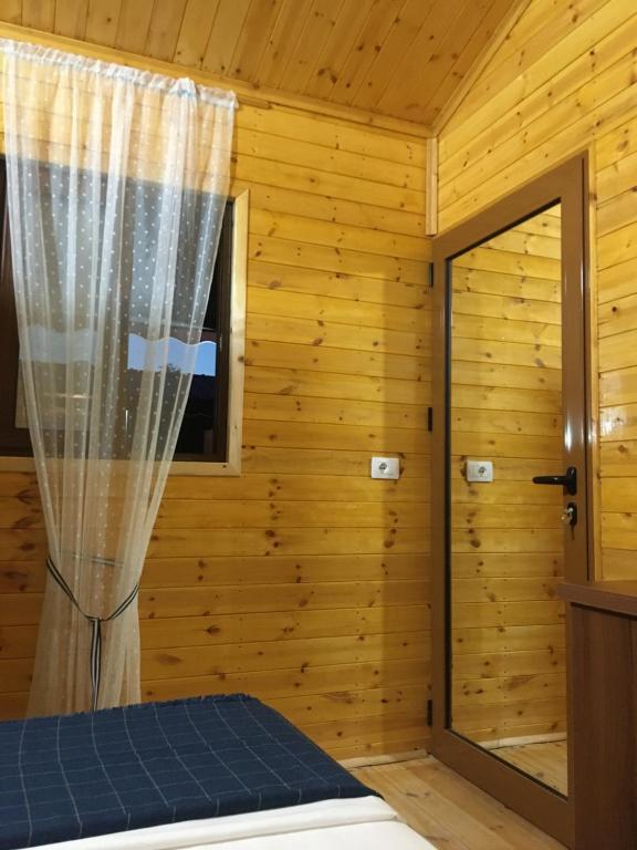 a log cabin bedroom with a bed and a window at Violet Village in Borsh