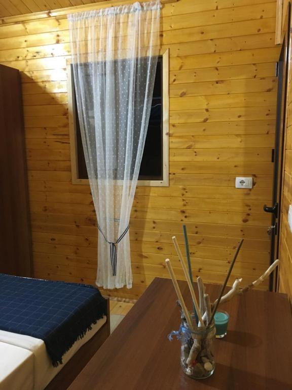 a room with a bed and a table with a window at Violet Village in Borsh