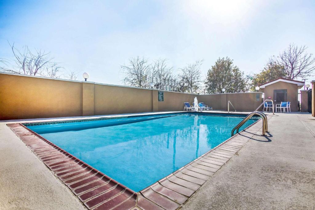 a swimming pool with blue water in front of a building at La Quinta by Wyndham Kyle - Austin South in Kyle