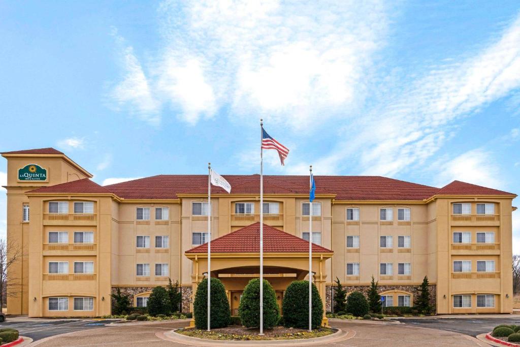 a hotel with two american flags in front of it at La Quinta by Wyndham Stillwater -University Area in Stillwater