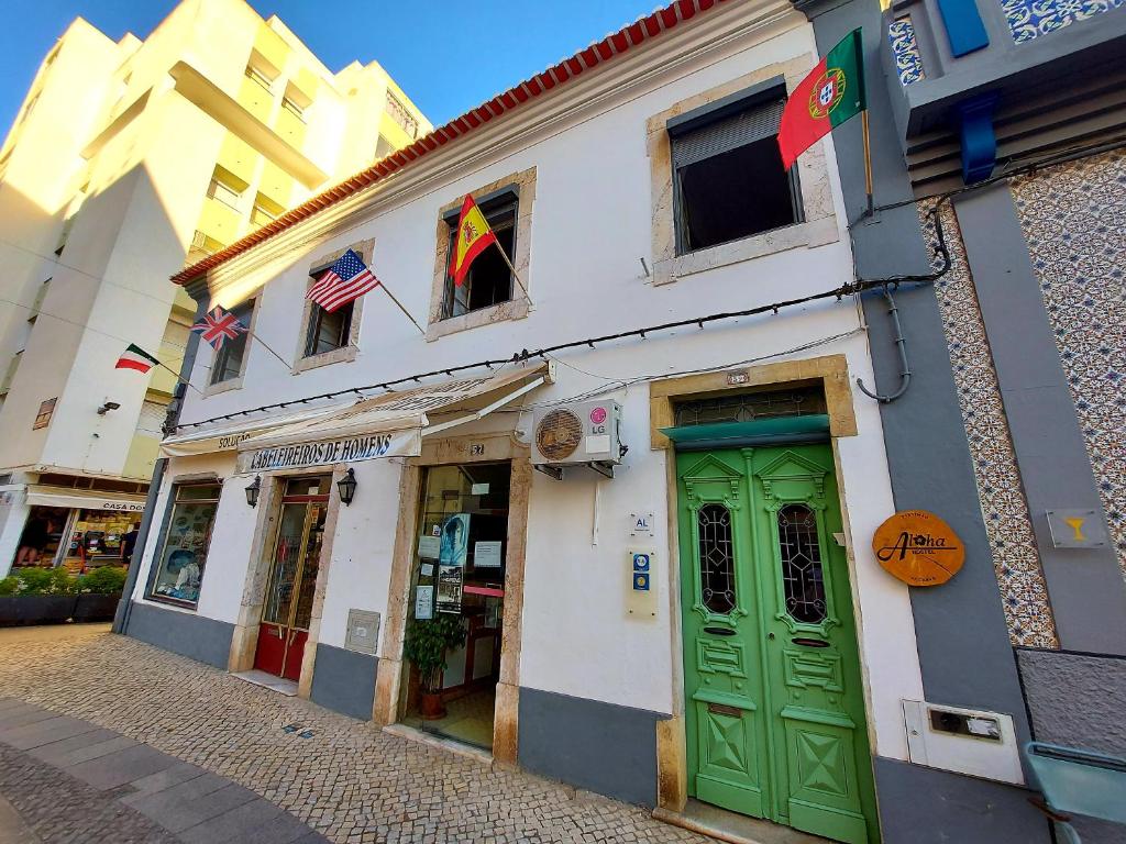 un edificio con puertas verdes en una calle en Aloha Hostel, en Portimão