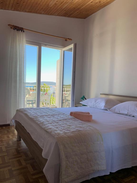 een slaapkamer met een groot bed en een groot raam bij Roca Apartments in Vodice