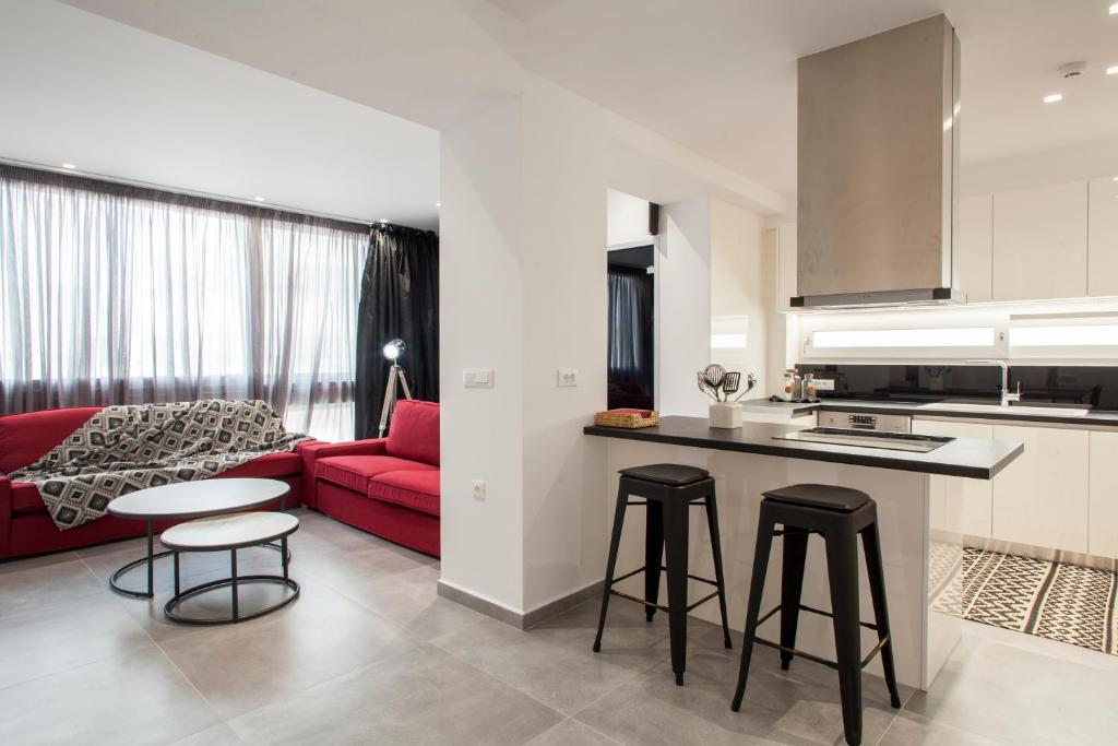 a kitchen and living room with a red couch at Emfasis Loft Spacious and Elegant Heraklion in Heraklio Town