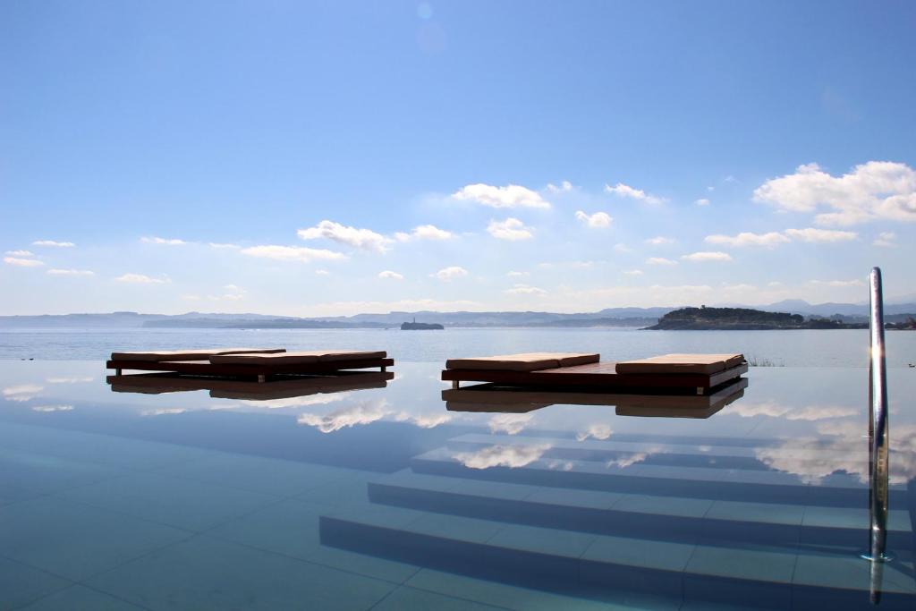 dos barcos sentados en el agua en un lago en Hotel Chiqui, en Santander