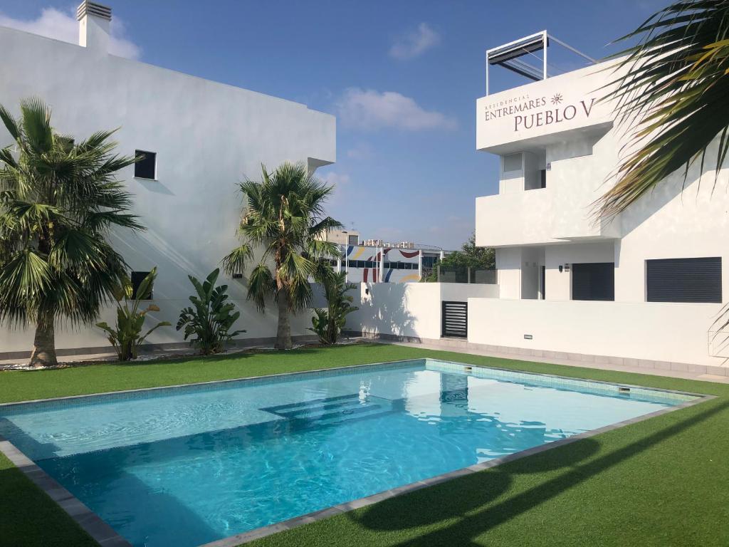 a swimming pool in front of a building at Entremares in Lo Pagán