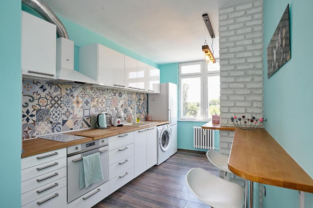 a kitchen with white cabinets and blue walls at Sunset Smart Home in Varna City