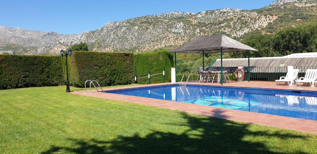 a swimming pool in a yard with a table and chairs at Casa Rural Huerta Vallejo in Ronda