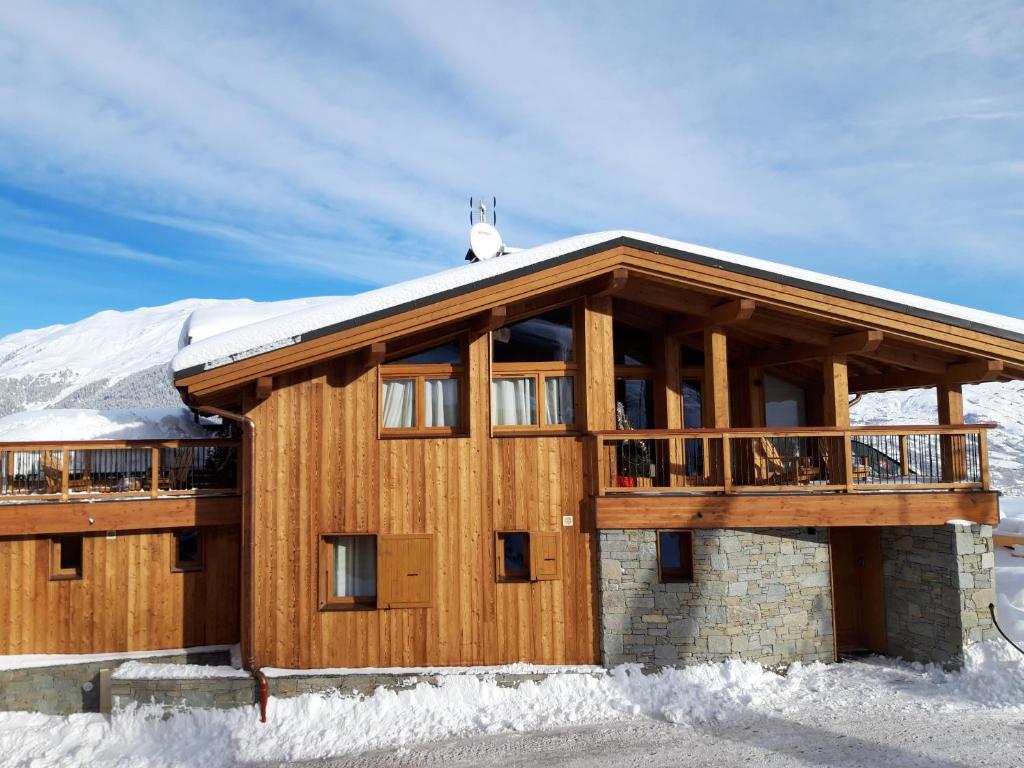 a large wooden house with snow on the roof at CHALET L'AULP in Montalbert