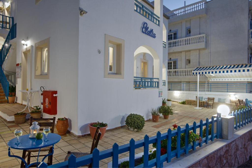 ein weißes Gebäude mit einem blauen Zaun und einem Tisch in der Unterkunft Elalia Apartments in Hersonissos