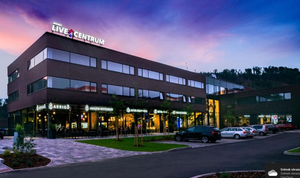 un grande edificio con auto parcheggiate in un parcheggio di ARMEX LiveCentrum a Děčín
