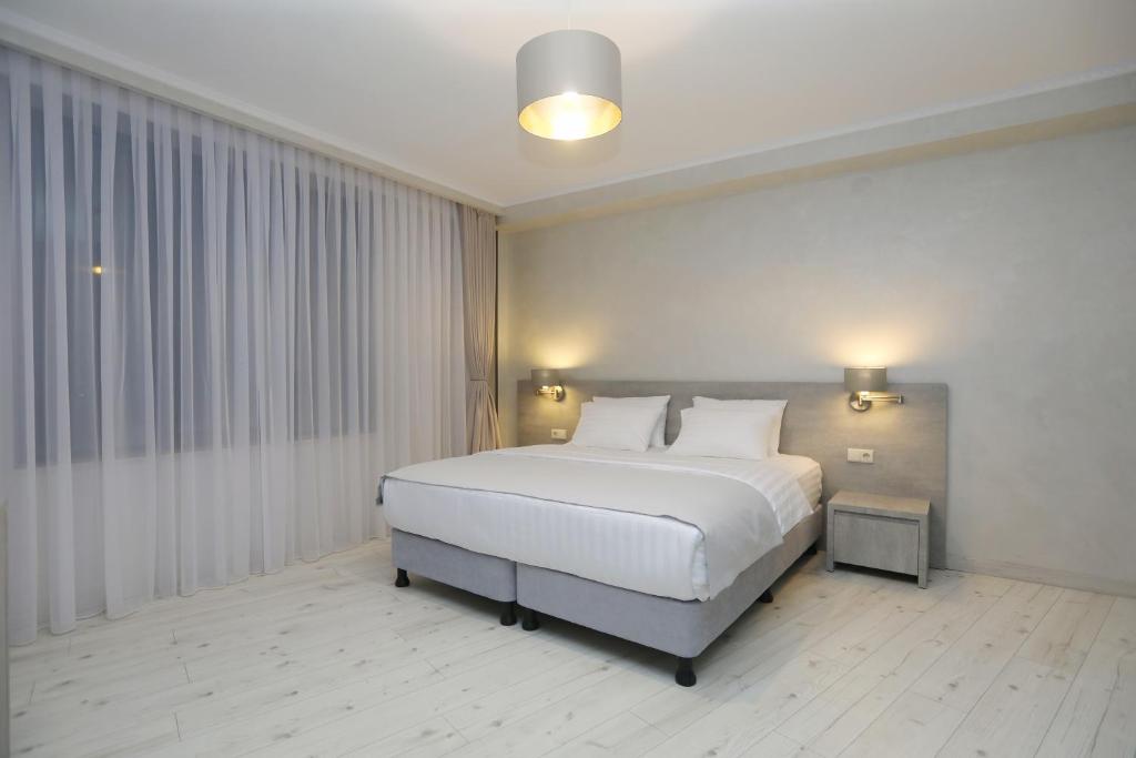 um quarto com uma grande cama branca num quarto em Sunset Terrace Mestia em Mestia