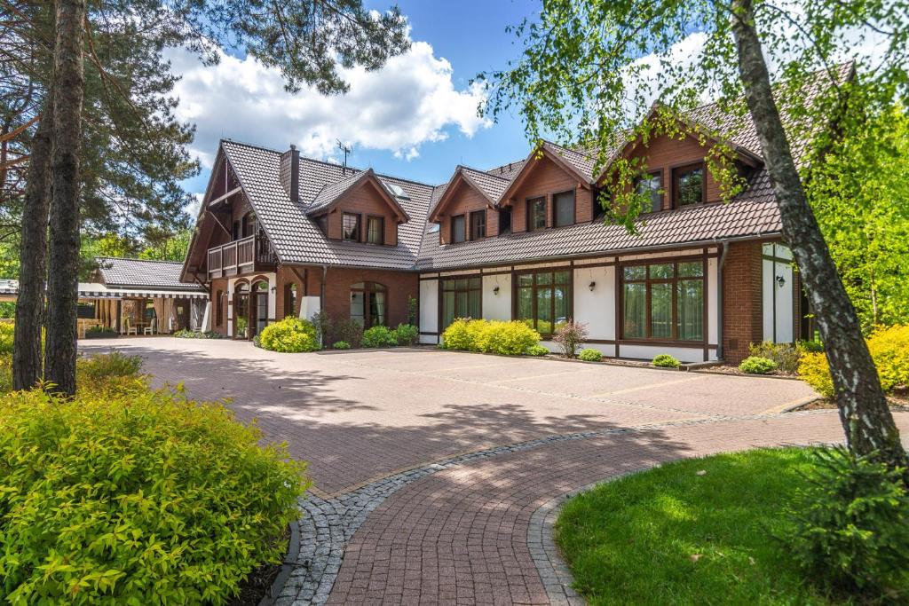 a large house with a brick driveway at Osada Grzybowski Młyn in Grzybowski Młyn